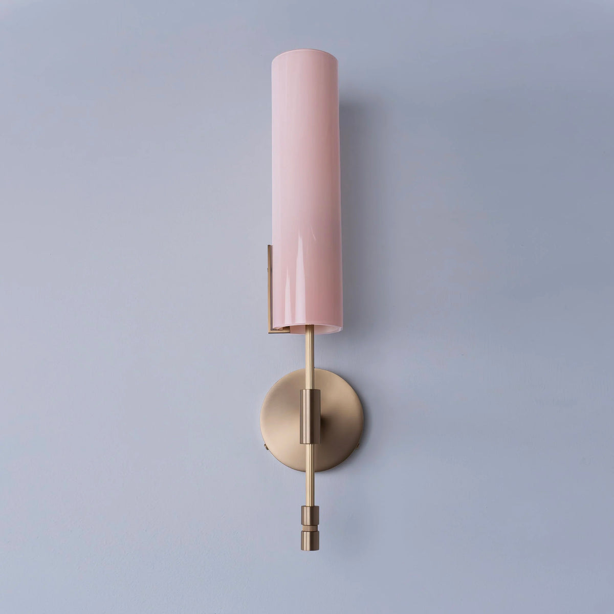 Avram Rusu sconce with pink cylindrical shade and brass wall attachment.