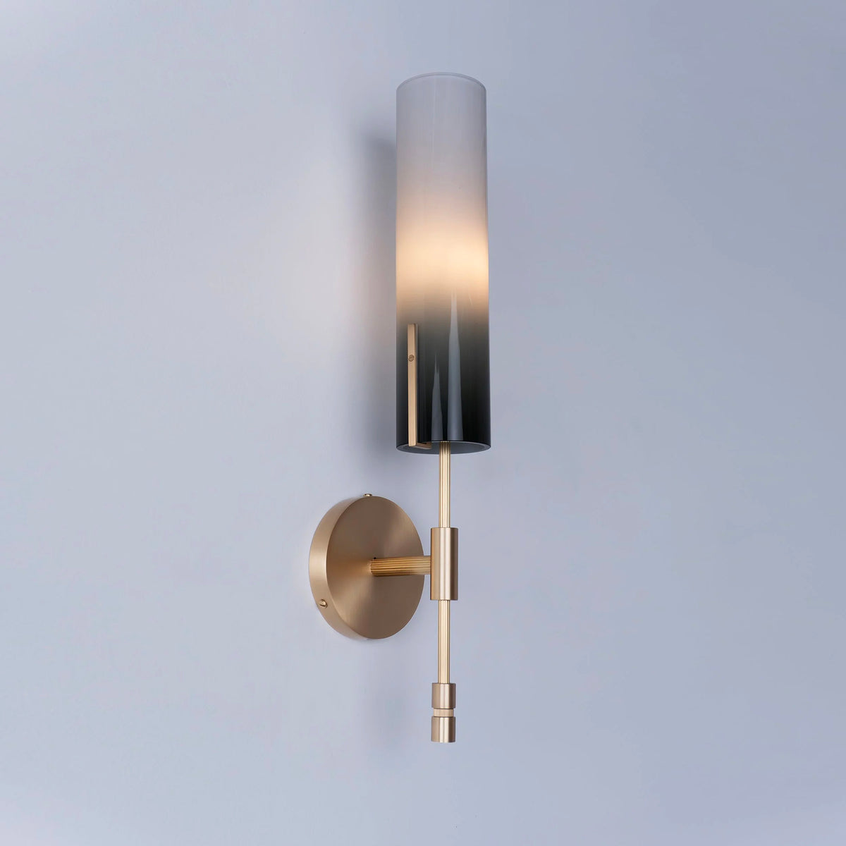 Modern wall lamp with hand blown gradient glass shade and brass detail.