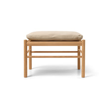 Wooden stool with a beige cushion 